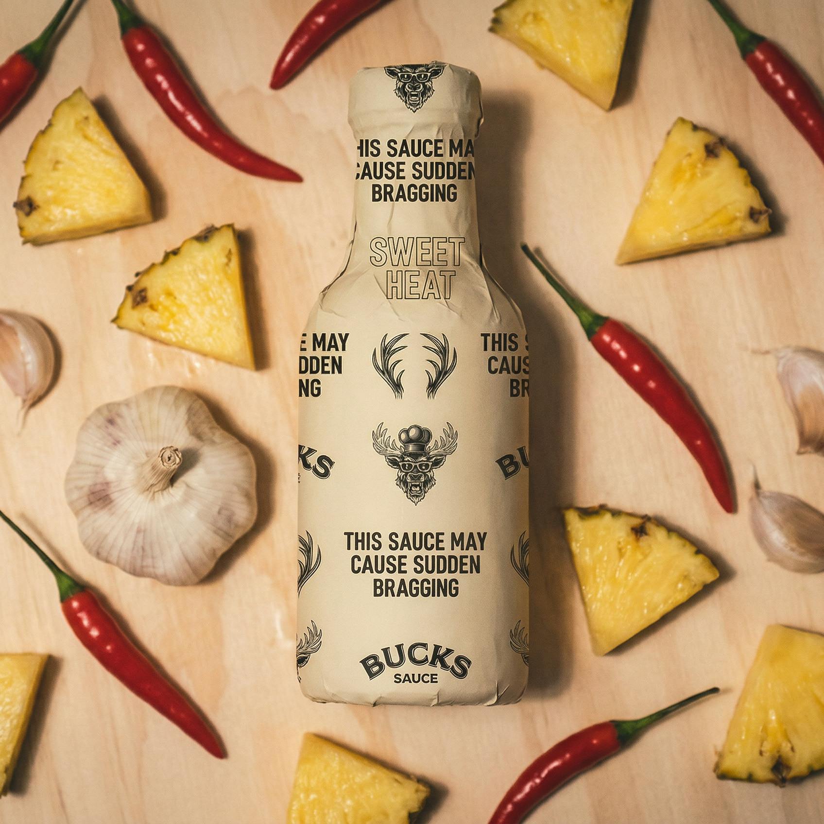 Pineapple, chillies and garlic around a Bucks Sauce bottle
